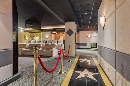 Experience movie nights like never before in this private theater, complete with soundproof walls, plush reclining chairs, a projector screen with remote-controlled curtains, and authentic cinema-inspired details throughout