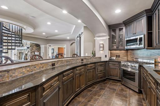 Kitchen features dishwasher, gas stove, range, microwave, and beverage refrigerator
