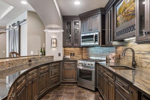 Kitchen features dishwasher, gas stove, range, microwave, and beverage refrigerator