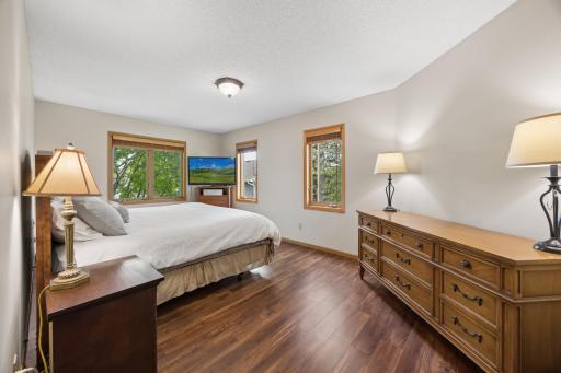 Spacious primary bedroom retreat with rich flooring, oversized windows, and calming natural light for a peaceful and comfortable atmosphere.