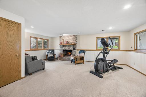 Expansive lower-level family room centered around a cozy brick fireplaceâperfect for movie nights, relaxing evenings, or entertaining.