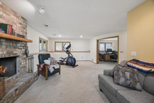 The spacious lower-level living area offers endless flexibility with room for recreation, fitness, media space, or gatherings around the fireplace.