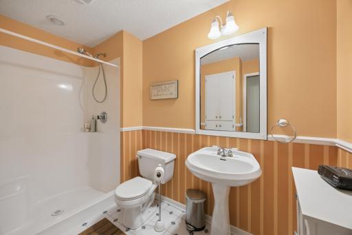 Stylish lower-level bath featuring warm designer-inspired tones and updated fixtures for added personality and charm.