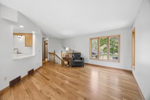Large windows flood the main living area with natural light while warm wood tones and freshly painted walls create a clean, timeless aesthetic throughout.
