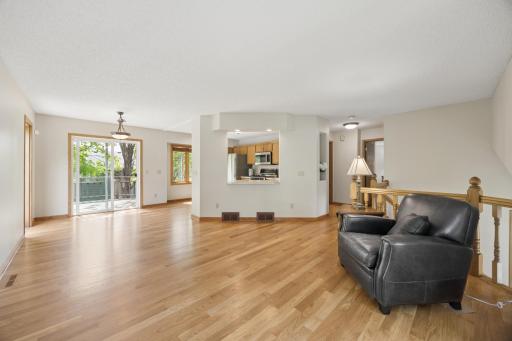 Sunlight pours into the living room, highlighting the newly refinished hardwood floors and airy open-concept layout designed for effortless everyday living and entertaining.