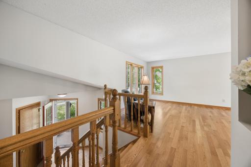 View from top of stairs looking down to entry and into the family room. The corner windows capture so much sunlight!