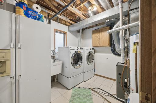 The large laundry space is bright and inviting. Also, the extra refrigerator is staying with the home!
