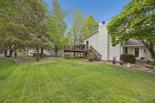 Enjoy a private, tree-lined backyard with mature landscaping, generous green space, and a large elevated deck ideal for summer entertaining.