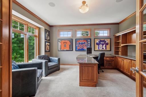Main level office with full built-in desk and shelving. Sun filled space with large windows!