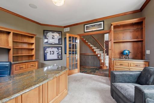 Executive office space with glass French doors, fabulous built-in shelving, desk, and drawers. A perfect work from home office or home command center for busy living.