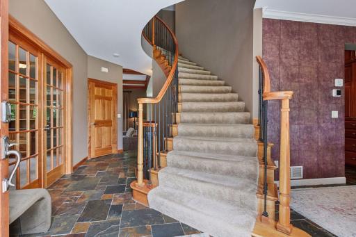 Beautiful curved staircase serves as a striking focal point, simple but elegant and showcases exceptional craftsmanship with custom wood railings, wrought-iron balusters, and elegant architectural detail this home offers.