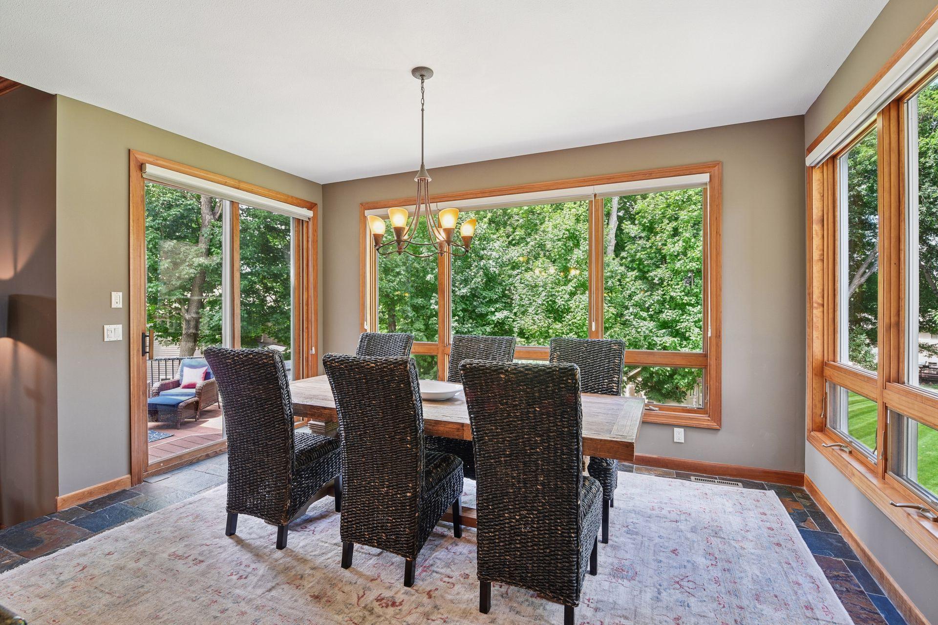Expansive windows surrounding the informal dining area flood the space with natural light and frame peaceful, wooded views, enhancing the home’s warm and inviting ambiance. Formal and informal dining options.