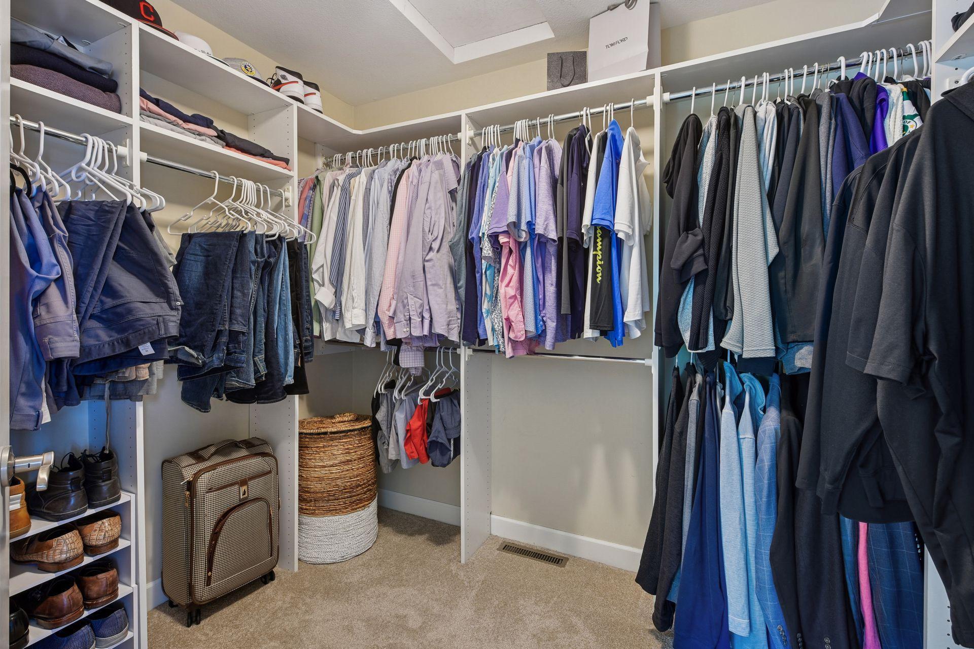 Large, primary walk-in closet with custom organization system provides exceptional storage and space!