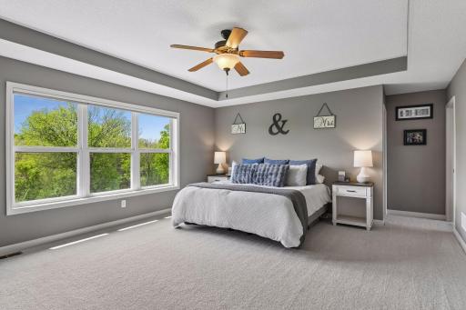Spacious primary suite features a large walk-in closet with custom organizers and a spa-like private bath