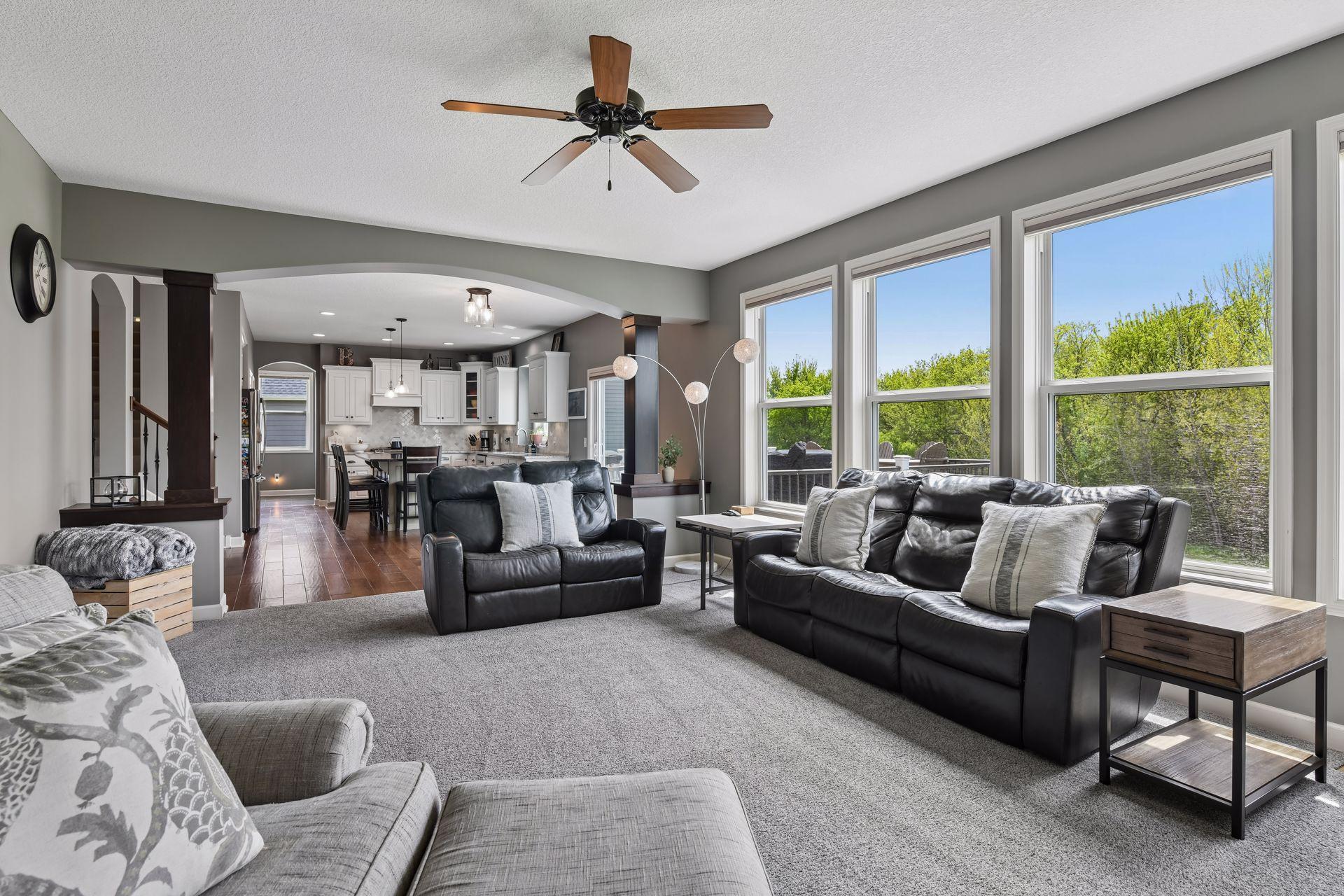 Bright and inviting family room with oversized windows and beautiful views of the backyard and mature trees beyond