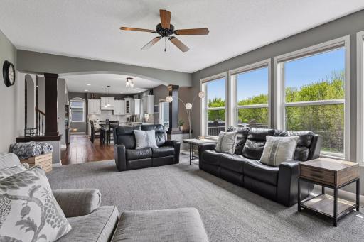 Bright and inviting family room with oversized windows and beautiful views of the backyard and mature trees beyond