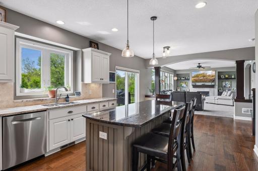 Open-concept kitchen with oversized windows, backyard views, and seamless flow into the dining and living spaces