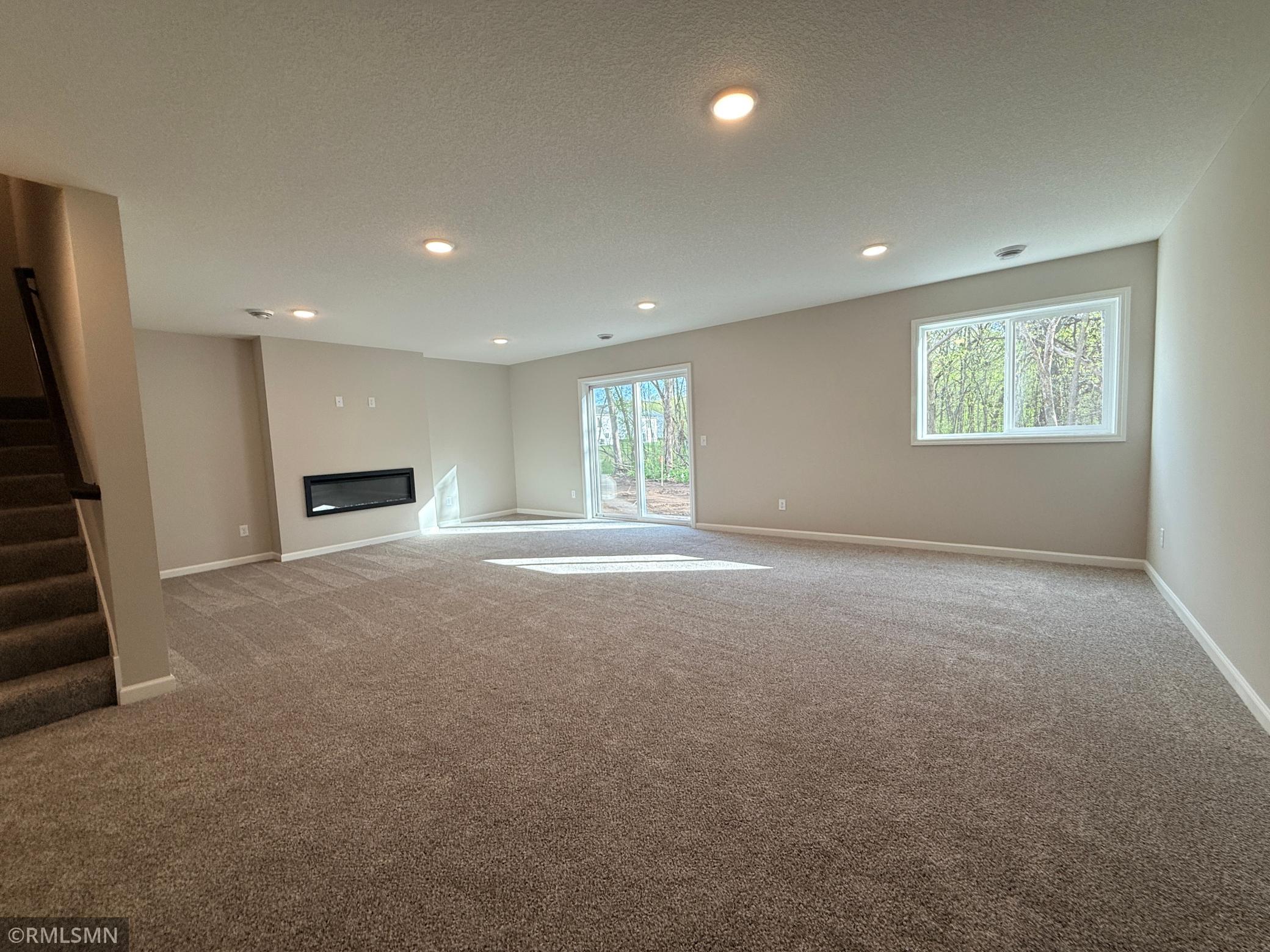 This huge family room features a sleek electric fireplace and walkout sliding doors leading to your treed backyard area.