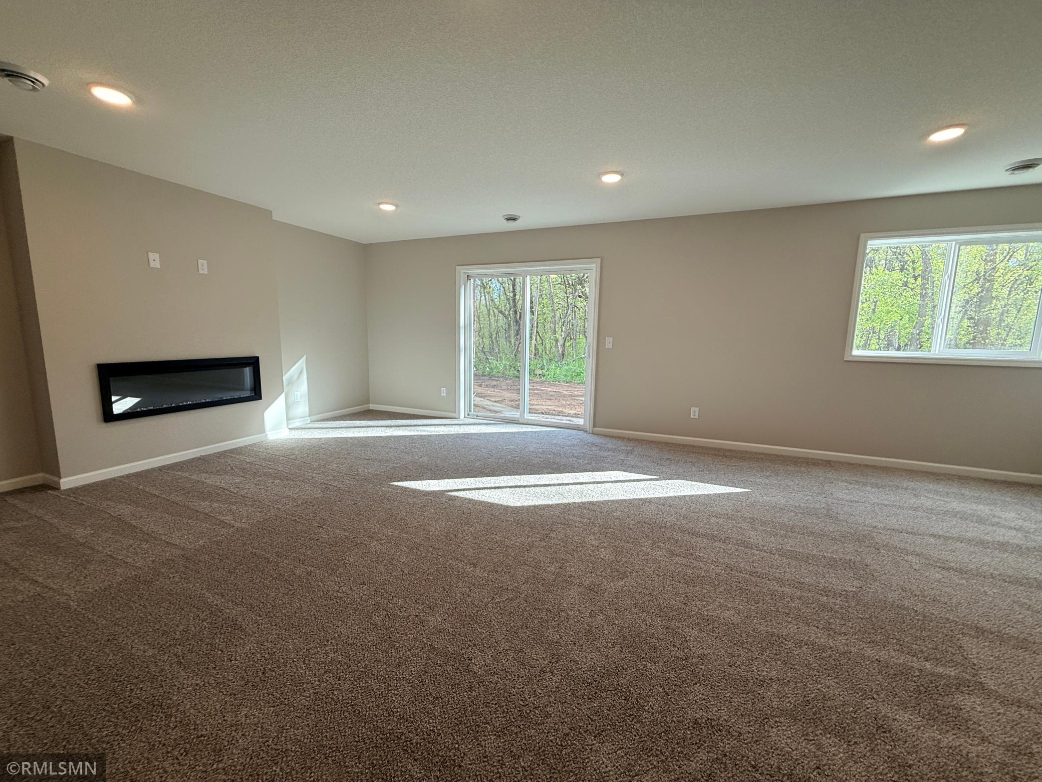 This huge family room features a sleek electric fireplace and walkout sliding doors leading to your treed backyard area.