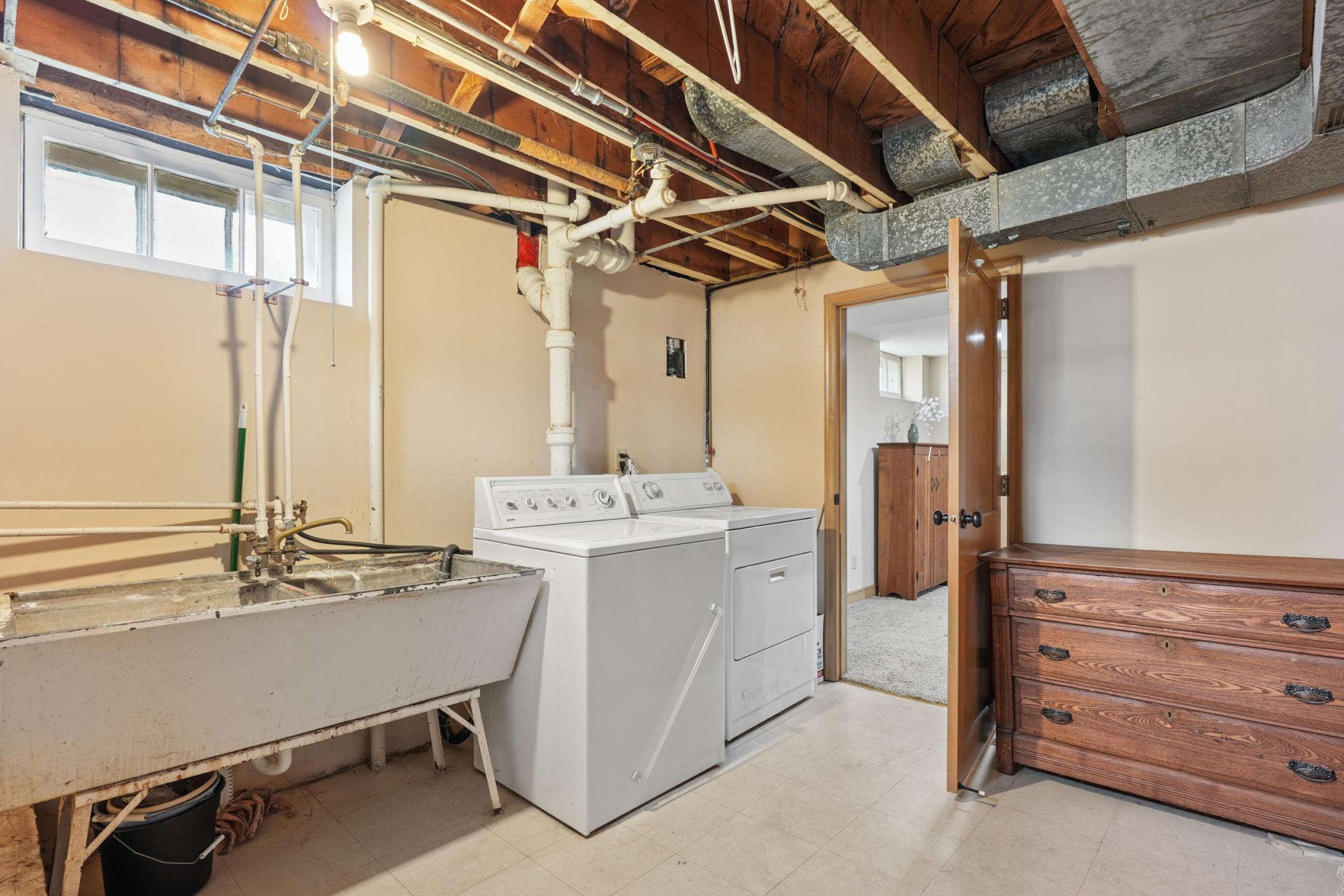 Separate laundry room in basement with extra storage space and a separate utility room