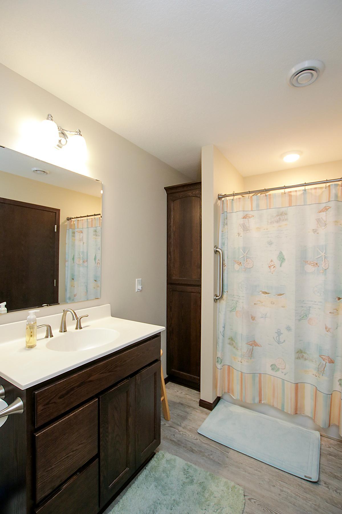 Primary bath with dark cabinetry and separate shower.