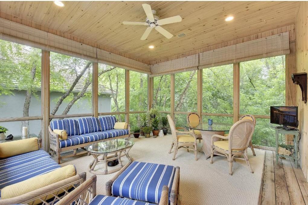 Wrapped in floor-to-ceiling windows on three sides, the screen porch captures elevated views of the yard and delivers an easy “Up North” feel, complete with a 10-foot ceiling, recessed lighting, and a ceiling fan for comfortable enjoyment