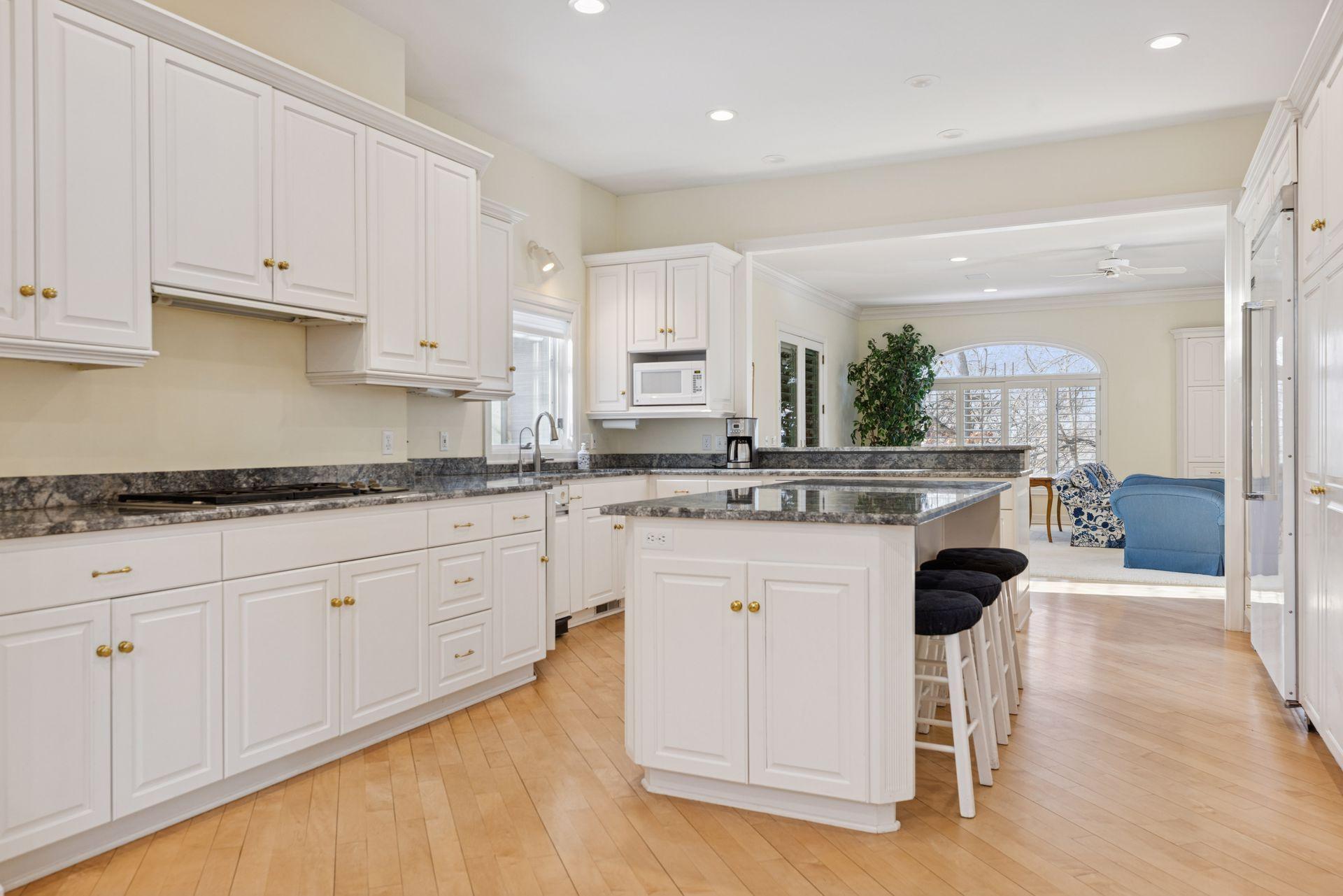 A five-burner Wolf gas cooktop, Viking French door refrigerator, and double Dacor wall ovens deliver professional-grade performance wrapped in a clean, timeless design