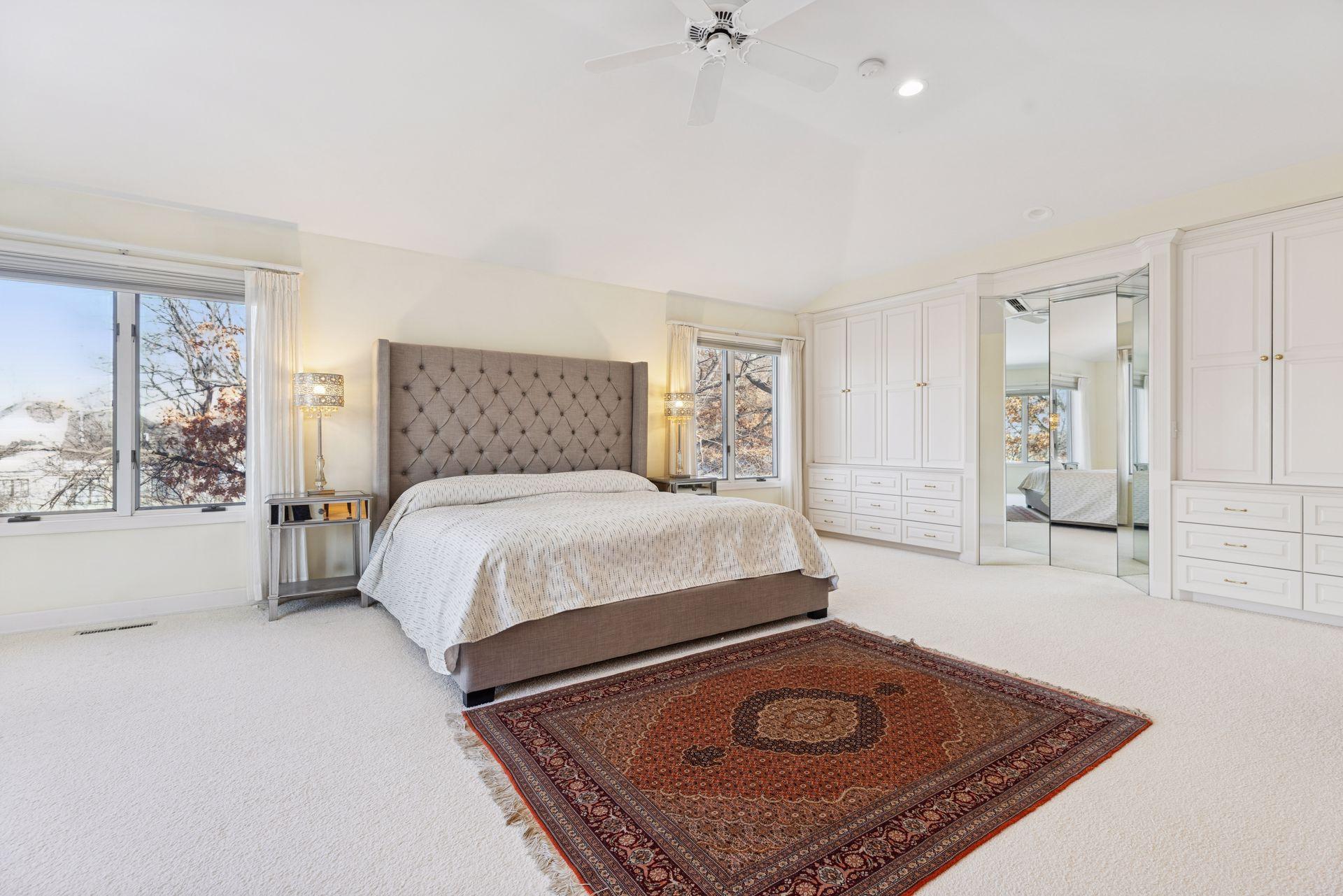 In addition to 2 walk-in closets, one full wall of built-in cabinetry creates exceptional storage, complemented by a three-angle floor-to-ceiling mirror that functions like a private dressing space