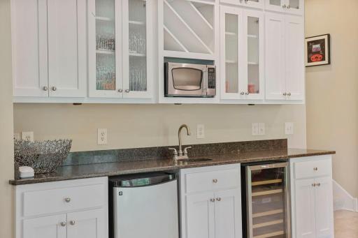 Basement kitchenette with fridge, microwave, and wine chiller
