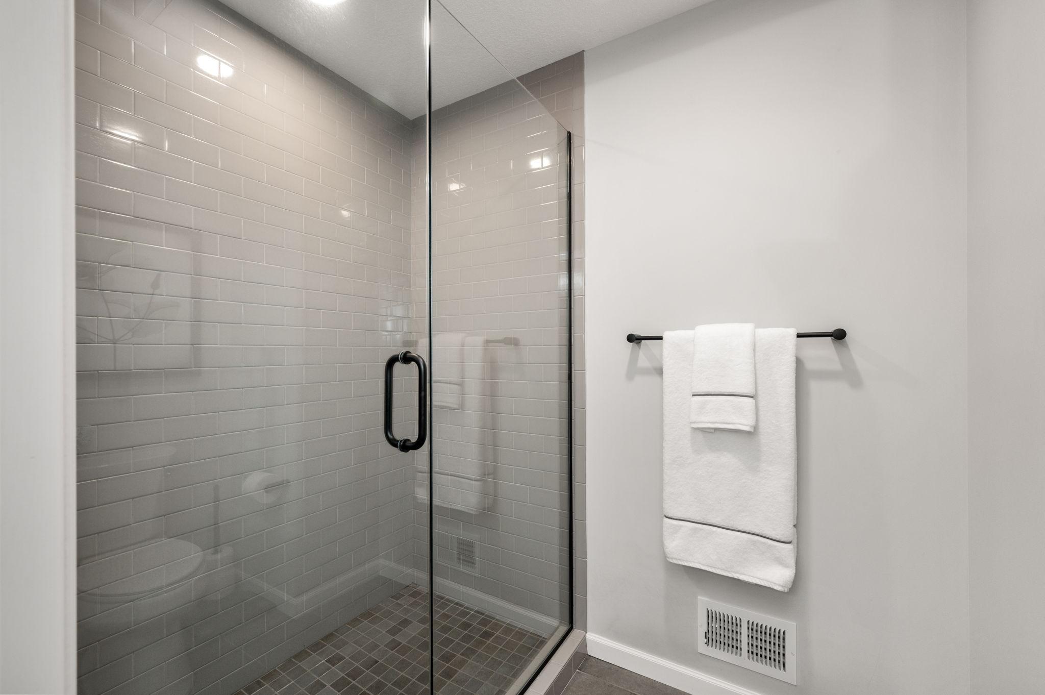 A luxurious Owner’s Suite with a walk-in shower with custom tile/glass door!
