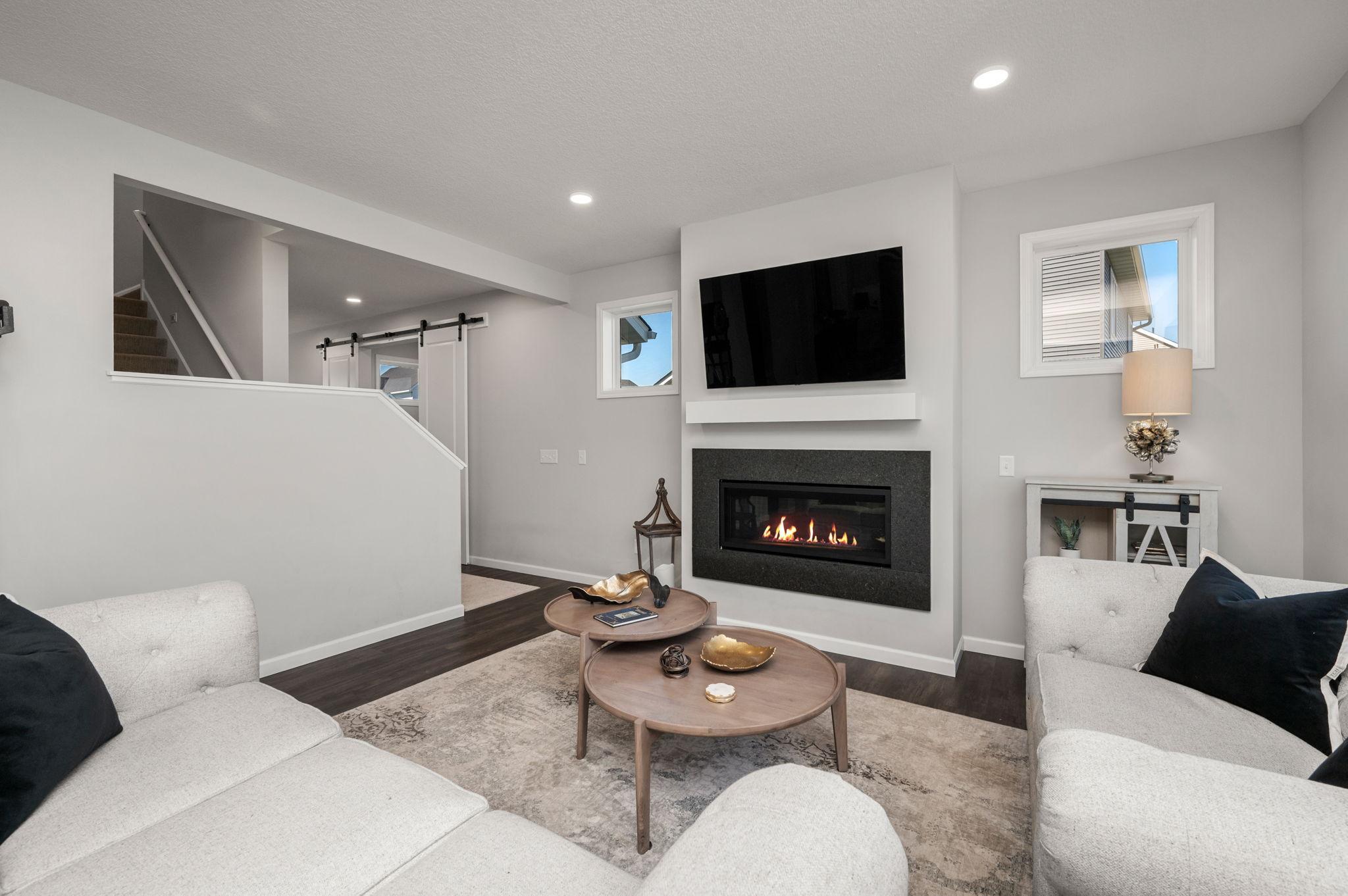 The main floor Living Room has a cozy gas fireplace and lot of natural lighting and windows!