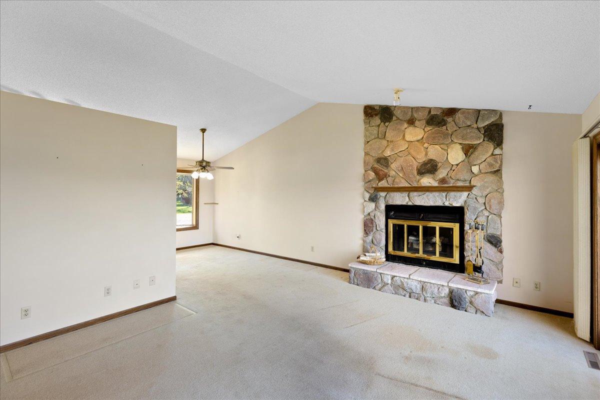 Cozy stone fireplace creates a warm focal point in the spacious lakeside living room.