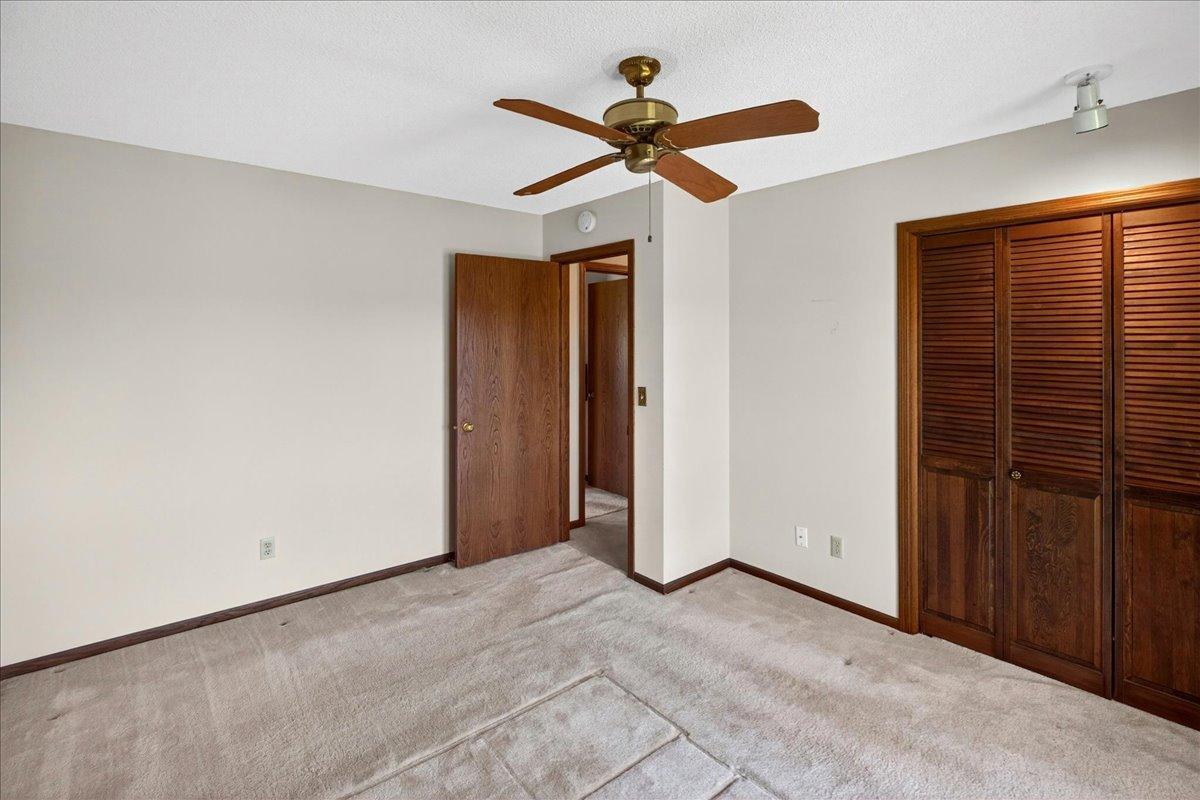 Bright upper-level bedroom with large windows and generous closet space.