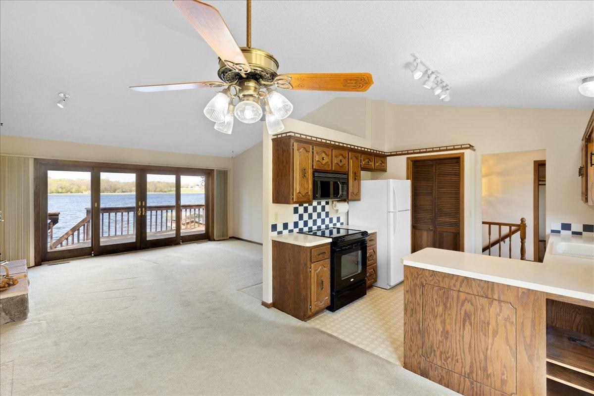 Open-concept kitchen, dining, and living space with vaulted ceilings and beautiful lake views.