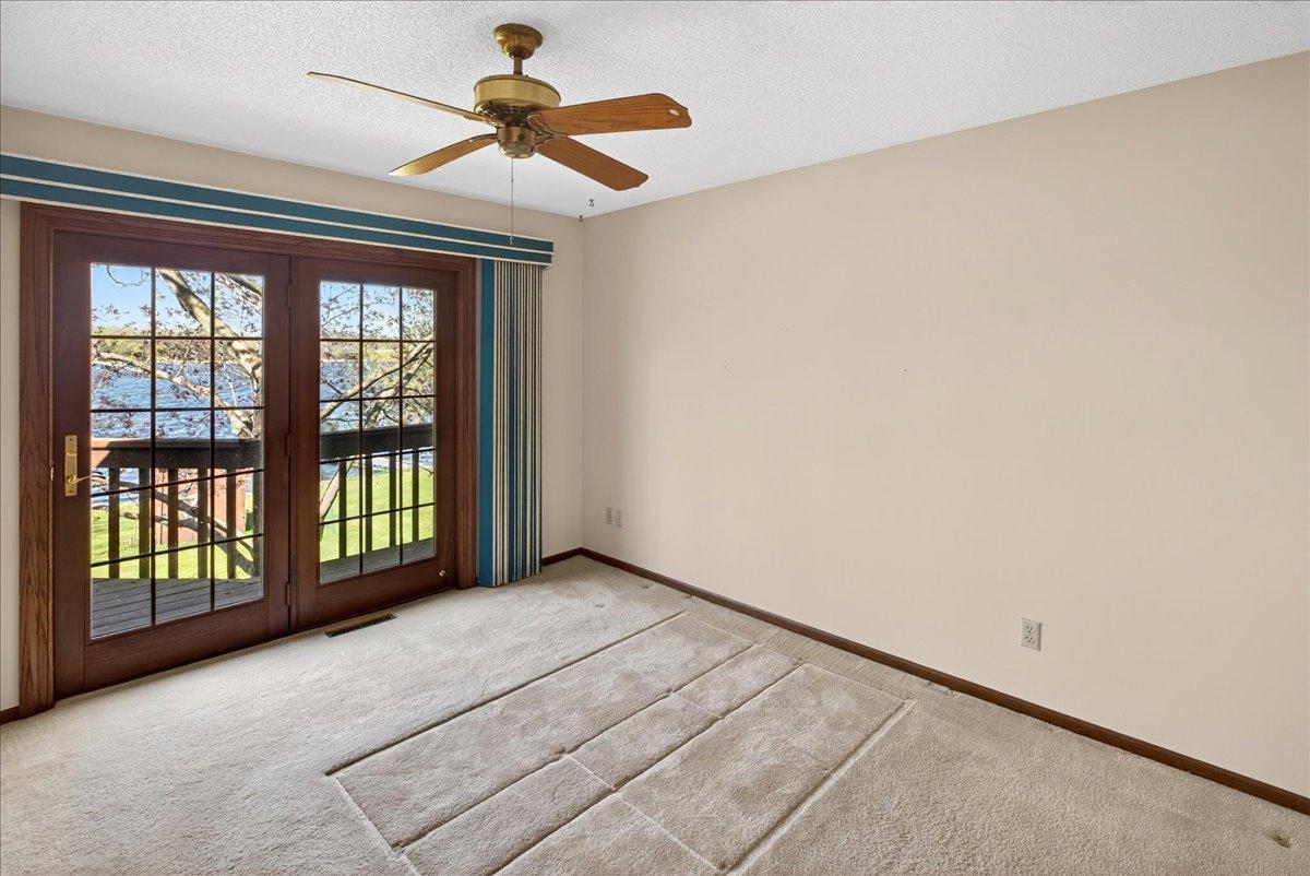 Primary lakeside bedroom with private deck access and beautiful water views.