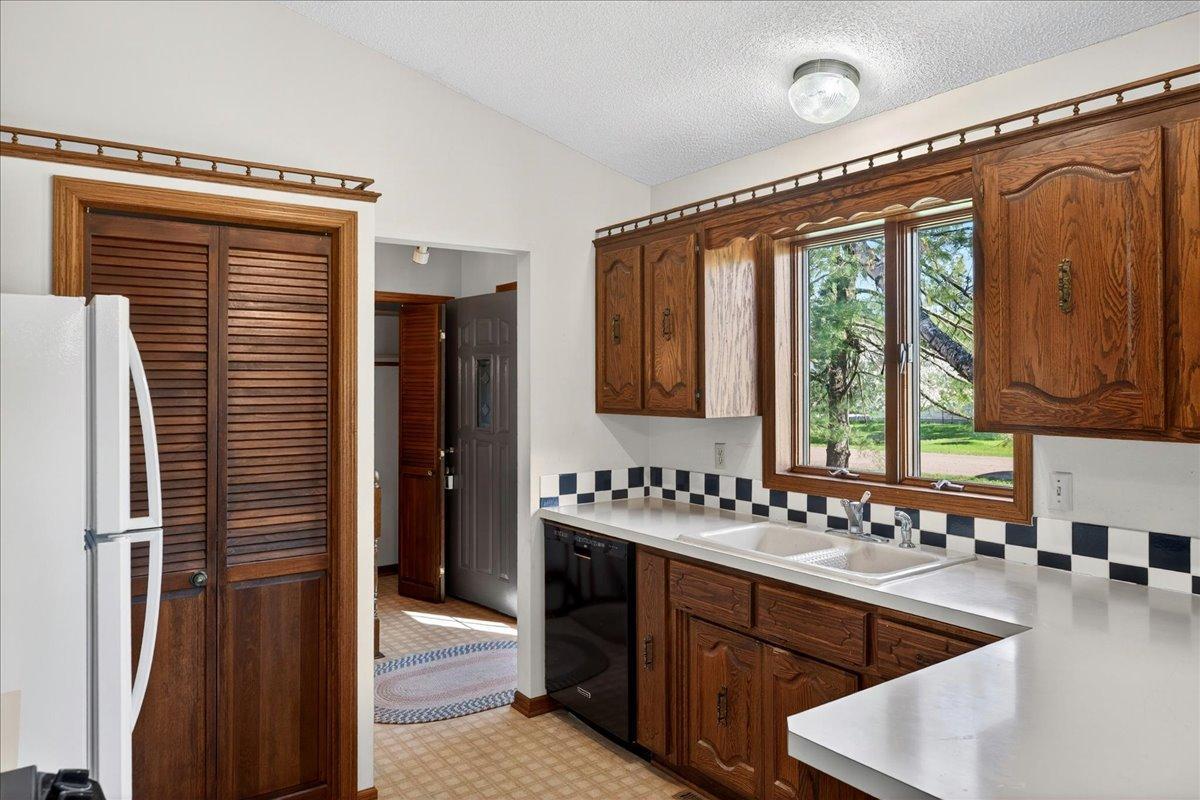 Bright kitchen with abundant cabinet space, breakfast bar area, and views overlooking the yard.