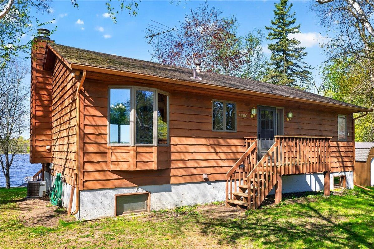 Welcoming front exterior with lakeshore views and a peaceful up-north feel.