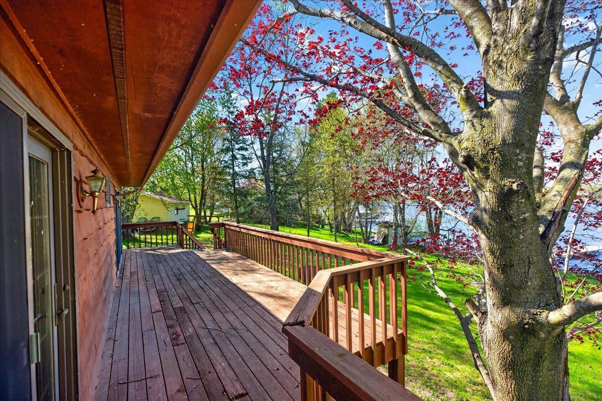 Large wraparound-style deck overlooking the yard and scenic lakeshore setting.