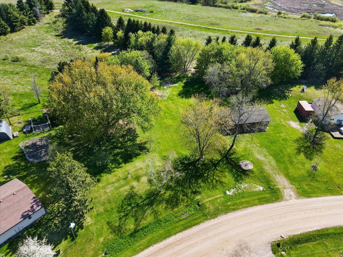 Elevated aerial view highlighting the extra parcels included with the property and detached garage location.