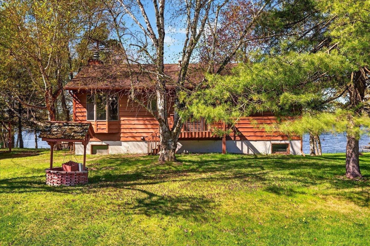 Charming lakeside home nestled among mature trees with a spacious yard and beautiful water views.