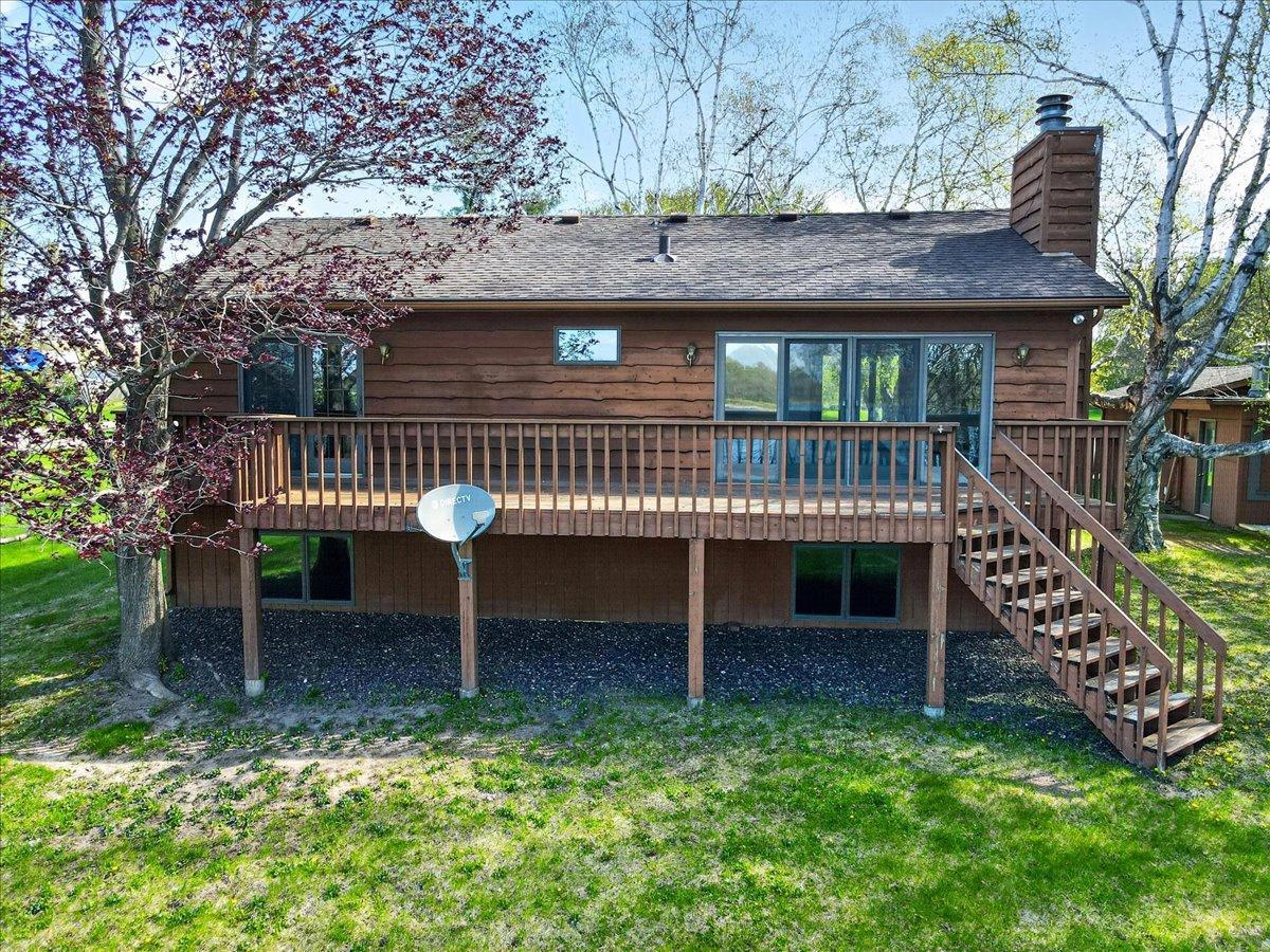 Rear exterior view highlighting the expansive deck and walkout access overlooking the lake.