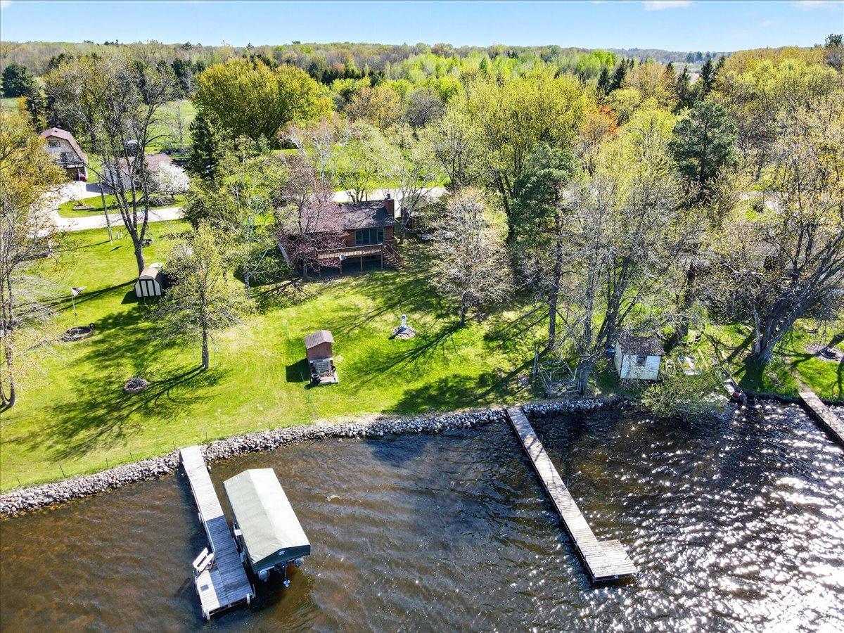 Dock to the right goes with the property. Excellent aerial view showcasing the lakeshore, dock, spacious yard, and peaceful setting on Rabour Lake.