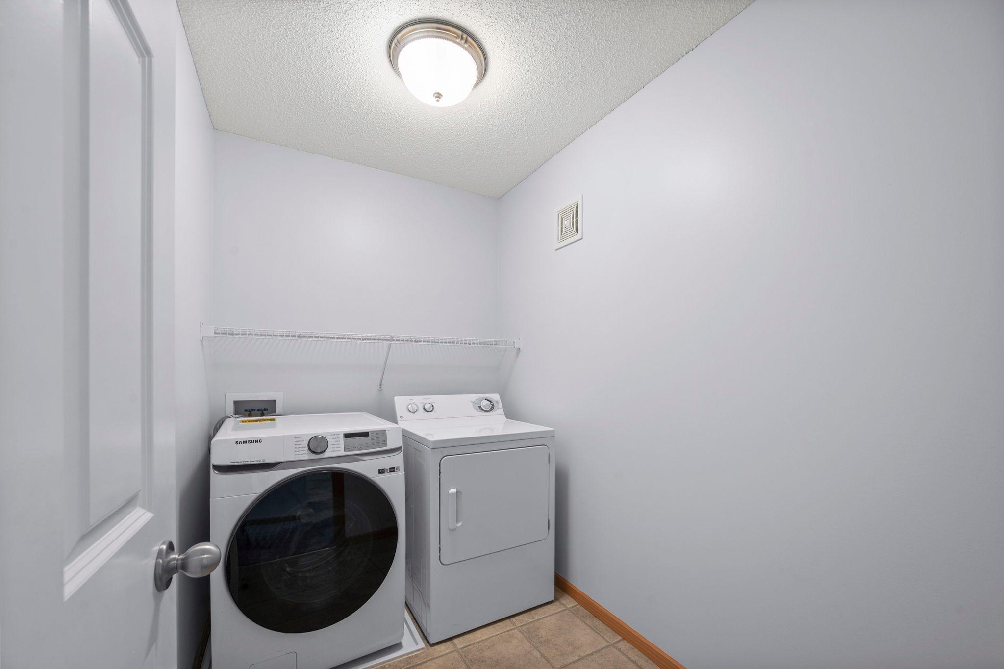 Convenient upper-level laundry room equipped with a modern front-load washer and dryer set.