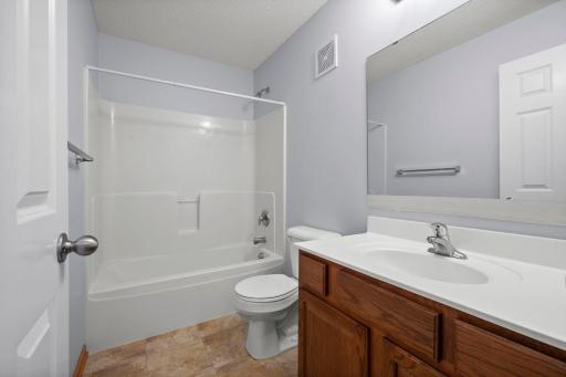 A second full bathroom on the upper level features a tub/shower combination and a classic wood vanity.