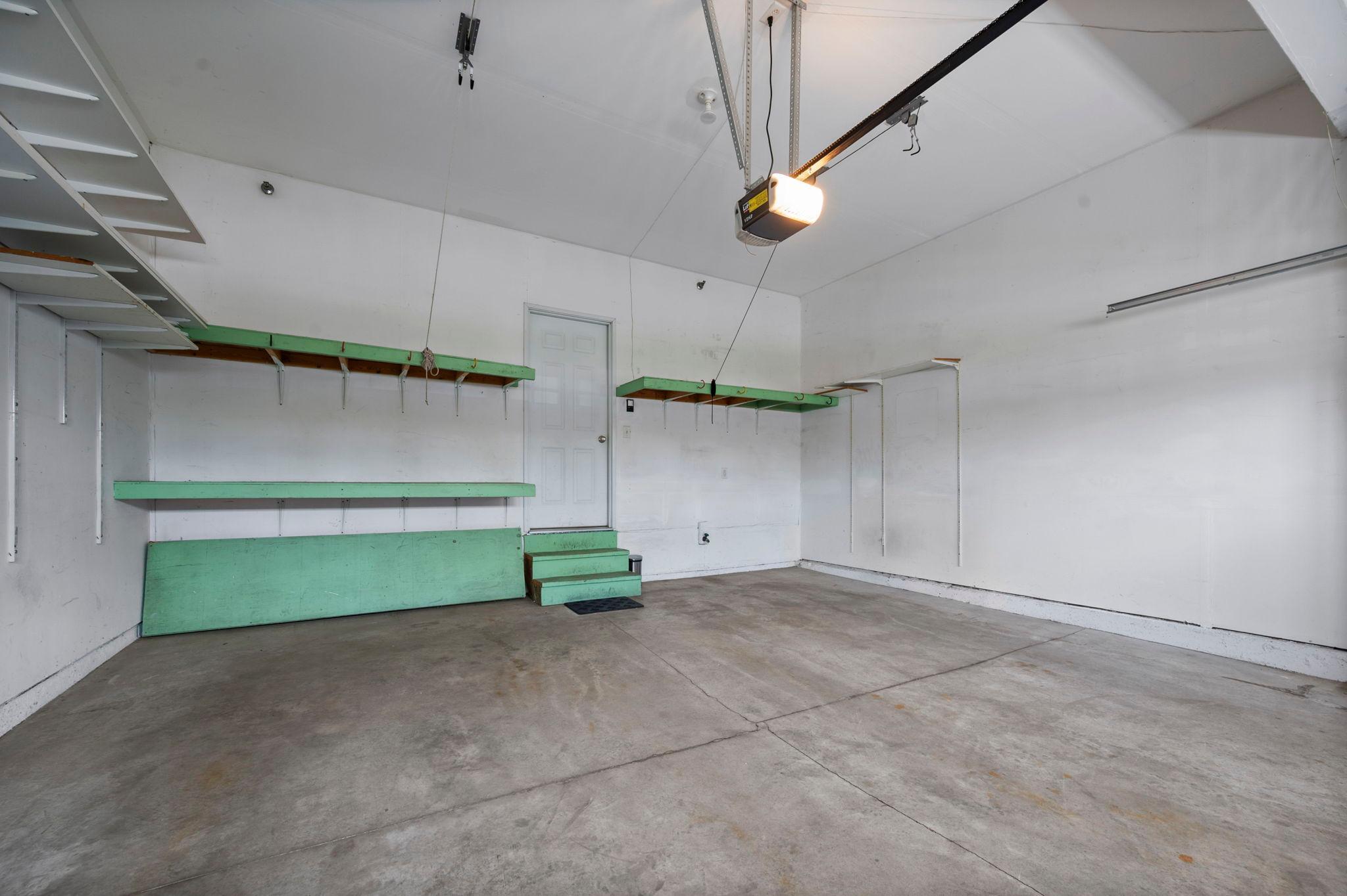 The spacious two-car garage is fully finished and includes built-in shelving and a convenient service door.