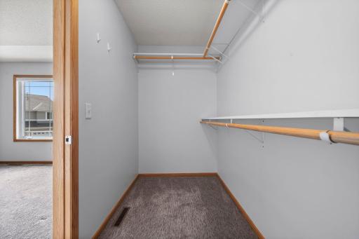 A generous walk-in closet provides ample storage with built-in shelving and hanging rods.