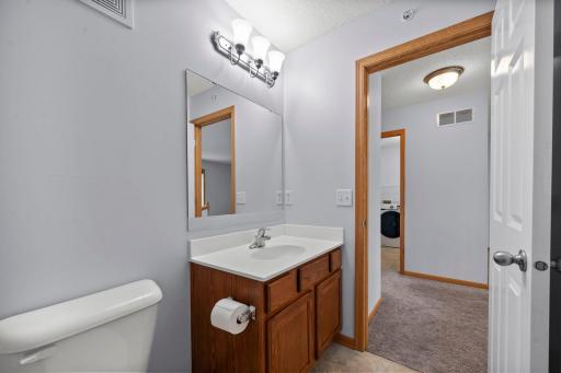 Well-maintained upper-level bathroom with ample lighting and a large vanity mirror.