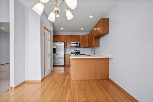The functional kitchen features warm oak cabinetry, stainless steel appliances, and a convenient breakfast bar for casual dining.