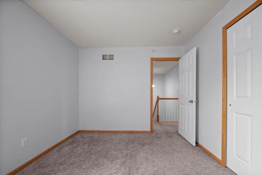 Another perspective of the third bedroom showing the view out toward the upper-level landing.