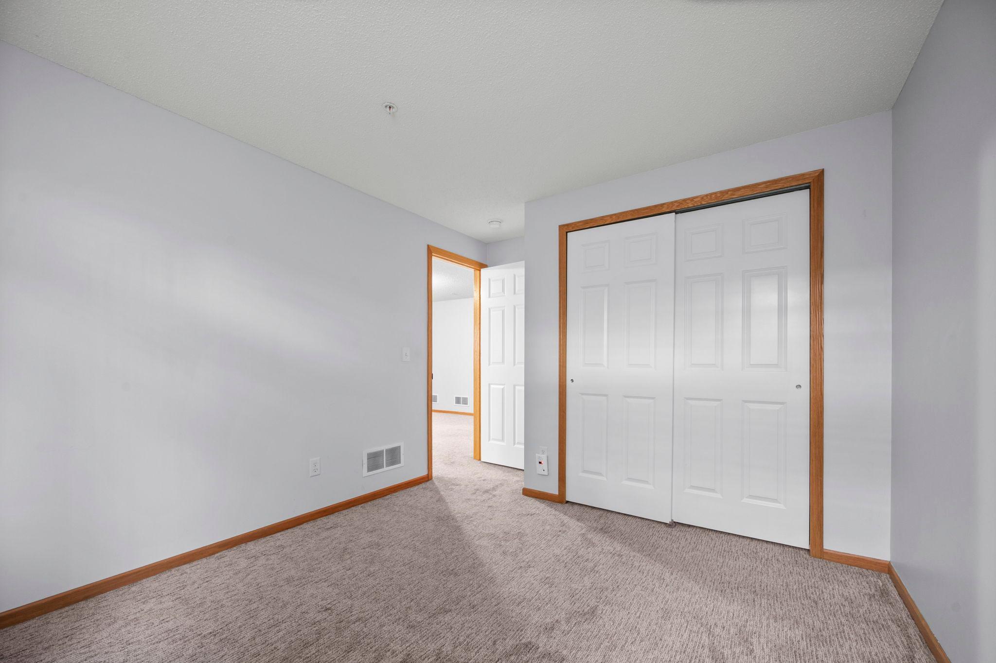 The lower-level bedroom includes a large closet with double sliding doors and plenty of space for furniture.